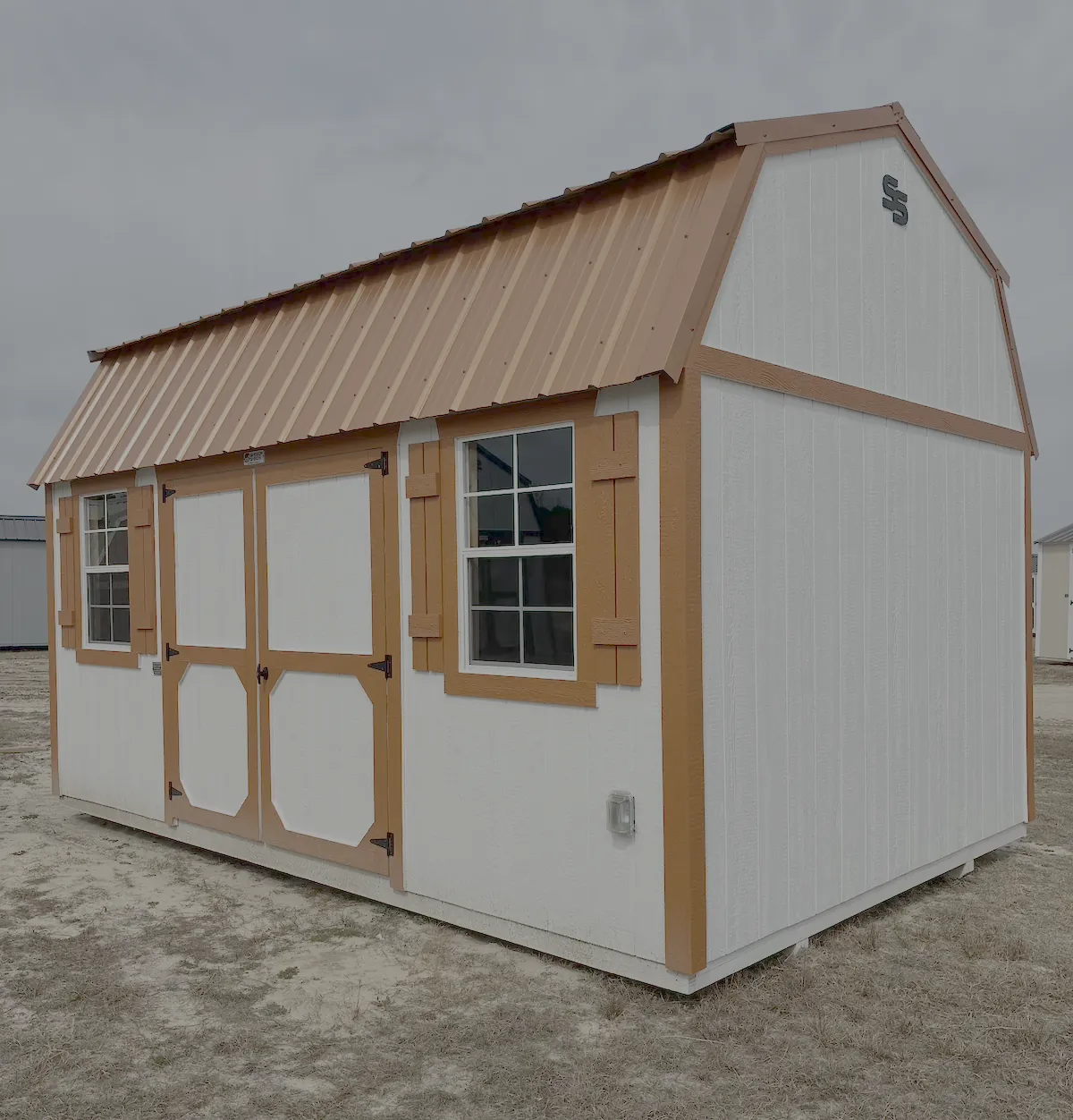 Lofted barn shed with tan trim and wide double doors under the gambrel loft
