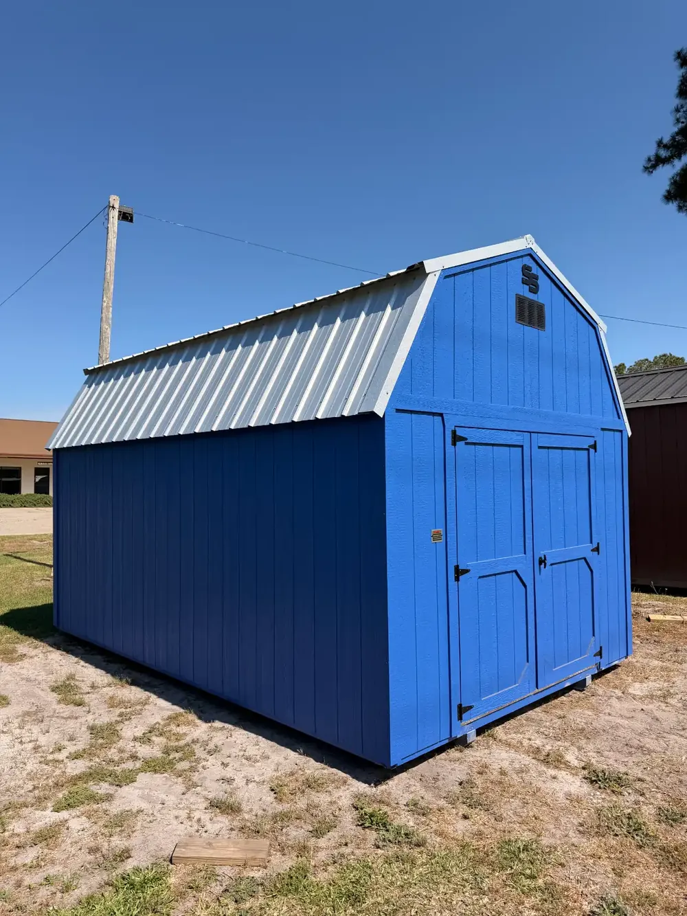 Bright blue lofted barn shed with white trim painted in a standard paint color