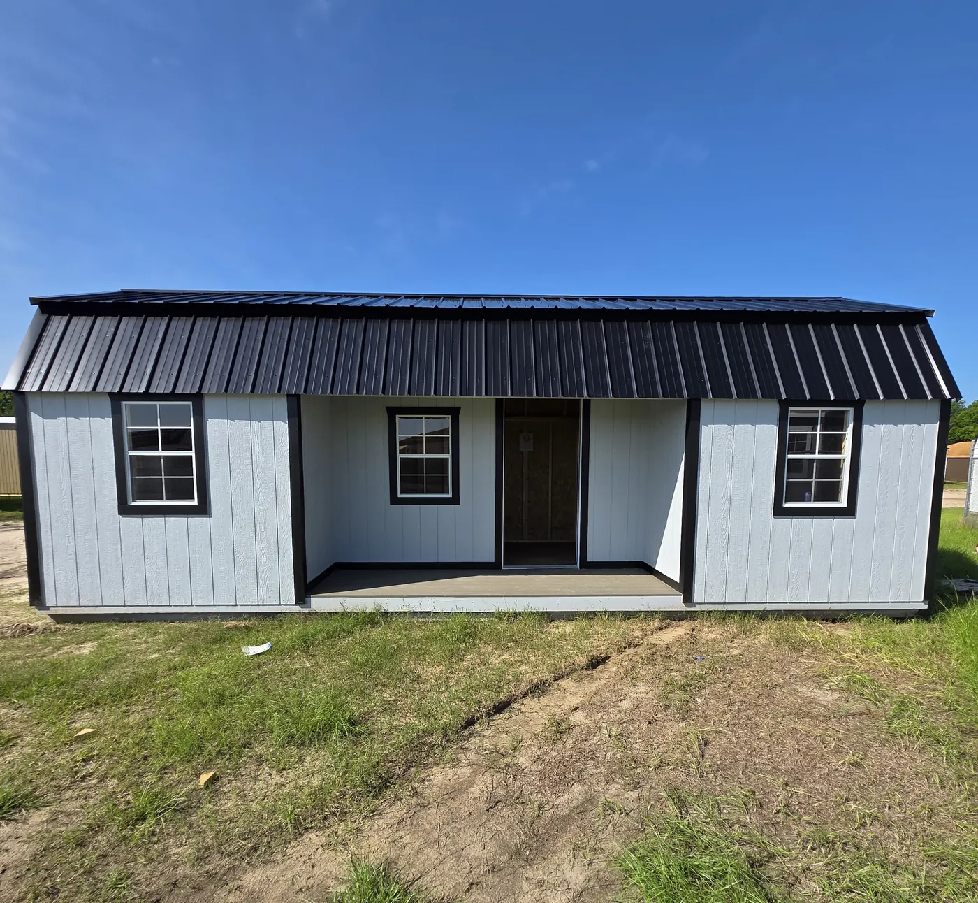 Center Porch Homesteader shed with a black metal roof and a recessed four-foot porch