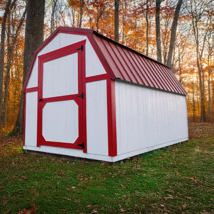 White lofted barn with a Crimson Red metal roof and matching red trim in autumn
