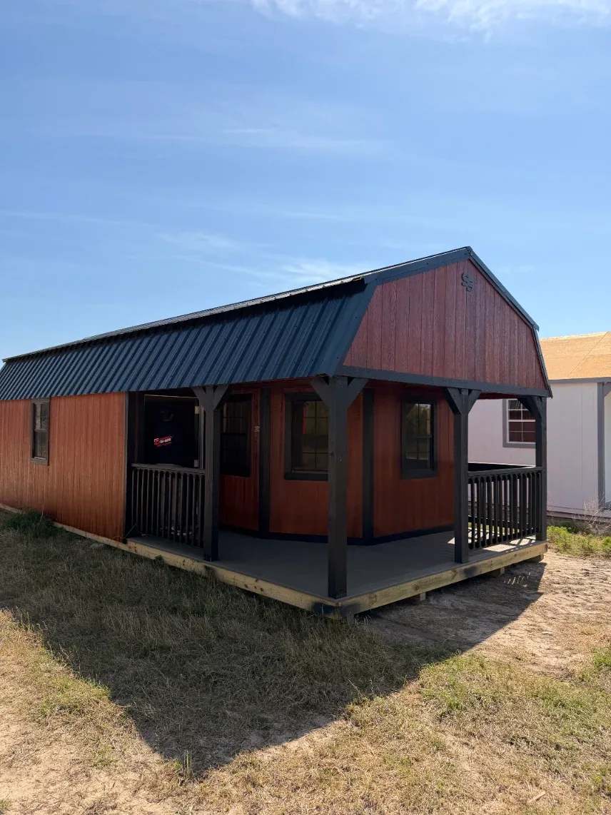 Mahogany stained cabin-style shed with a covered porch, showing the urethane stain finish