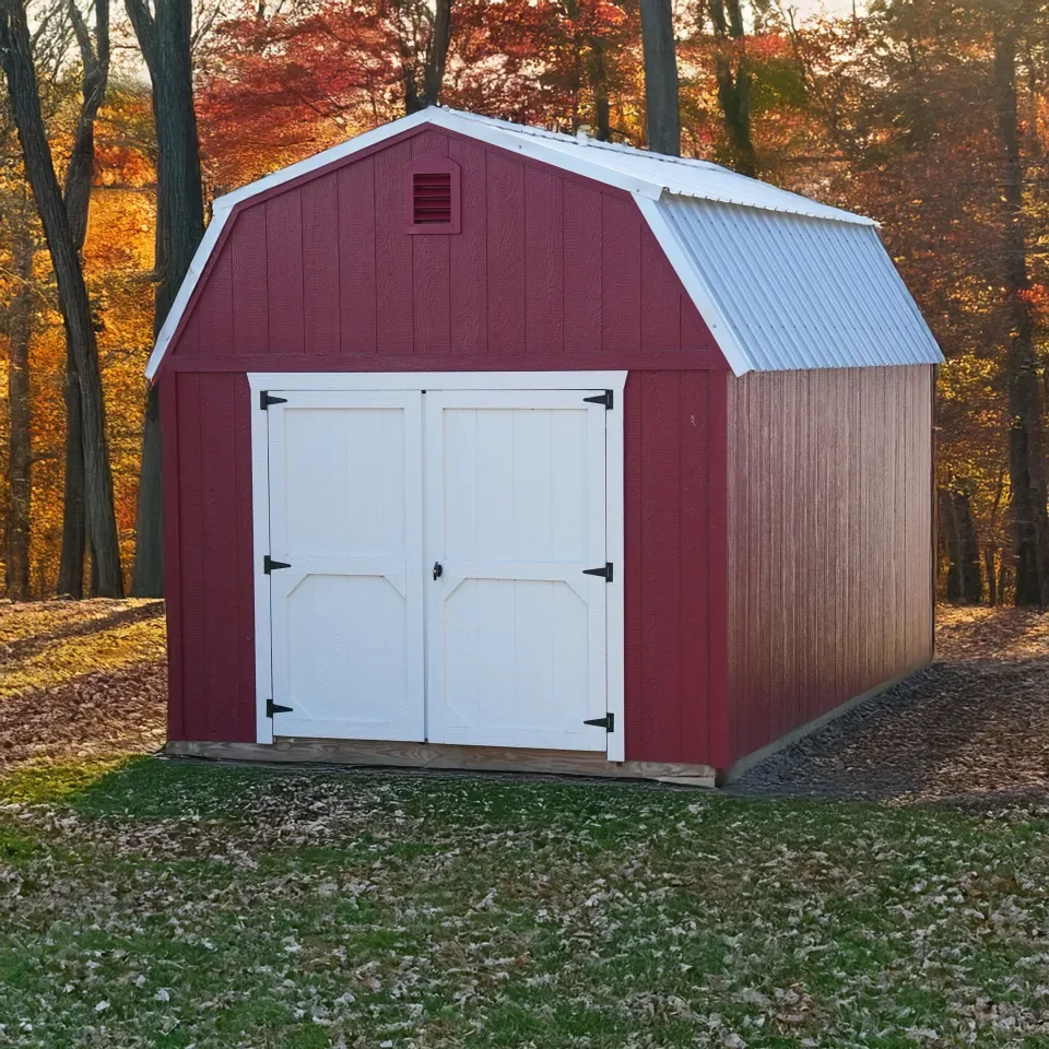Red Select Series lofted barn with white double doors on a lot in autumn